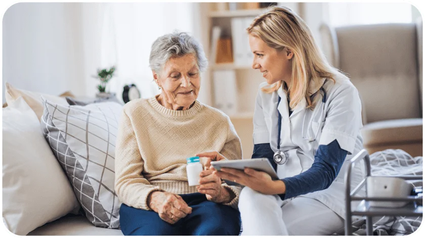 a health professional reminding an elderly woman to take her meds